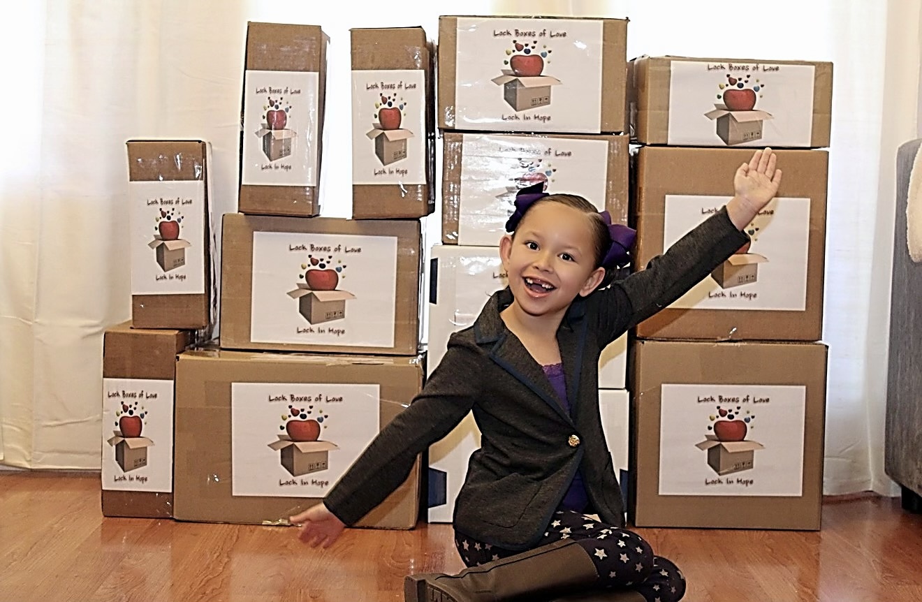 Young Emma standing with prepared Lock Boxes of Love